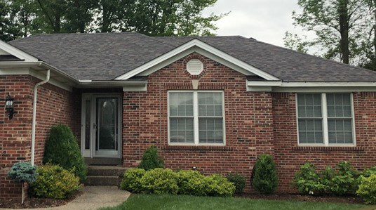 Brick house with new roof and gutters