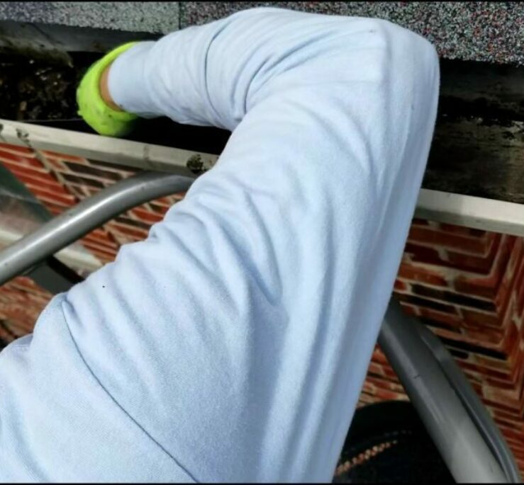 A man cleaning out a gutter